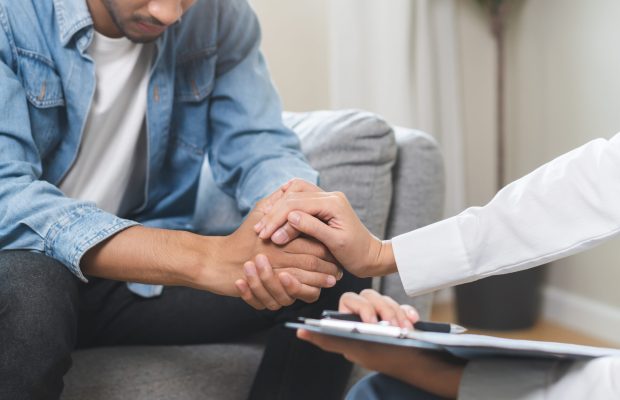 Psychology, depression. Sad asian young man consulting with psychiatrist while patient counseling mental therapy problem with doctor at clinic. Psychologist encouraging with sick mental health person.